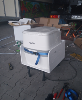 Das Toi-Toi in seiner Box. Die Schrauben des Gurtbandes haben nebenbei den Positiven effekt das das Porta-Potti nicht nach oben aus der Box herauskann.