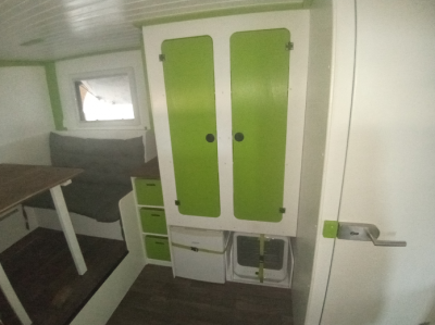 Auf der Fahrerseite ist ein großer Kleiderschrank, untendrunter ist Platz für den Kühlschrank und den Geschirspüler