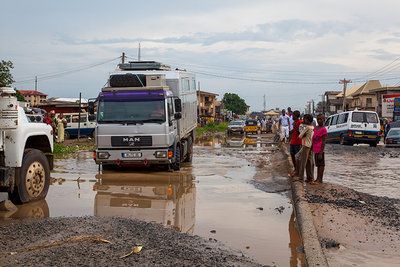 2015 mantoco Weltreise Nigeria Aba Stadtdurchfahrt mit Matsch riesigen Pfuetzen.jpg