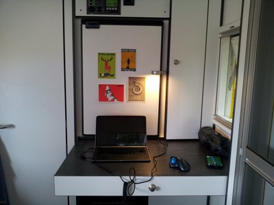 Ein ausziehbarer Tisch unter dem Kuehlschrank dient als Kartentisch und zusaetzliche Arbeitsflaeche fuer den Koch.