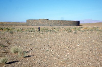 Die Spirale , um den Bauwerken ist ein Steinkreis von ca. 300m. Durchmesser gezogen , der ohne zu bezahlen nicht überschritten werden sollte ( darf ) . Auch darf ( sollte ) keiner mit eigenem Fahrzeug hier fahren . Besichtigung pro. Person 200 DH zu Fuß !! ca. 28 km. !! mit Führer im Landy noch einmal 600 DH = 1000 DH . Hallo ?! Die Steppe und die Pisten sind öffentliches Gelände .