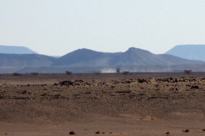 Wenn man auf den Hügeln der Gravuren steht , und Richtung Süden schaut , sieht man im Hintergrund die Schneise in der Bergkette , von der aus die Karavanen aus Algerien gekommen sind . Da wollten wir hin , aber schon nach 8 km. Piste stoppte uns das Militär und schickte uns umgehend zurück , schade .