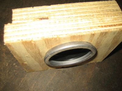 Druckstück aus Holz; der Blechring der neuen Manschette steht über und kann so aufgedrückt werden